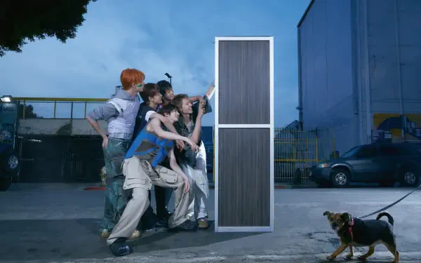 Cortis Color Outside the Lines 4K Ultra HD PC desktop background: a group of people push a tall freestanding door in an industrial lot at dusk while a small dog tugs on its leash.