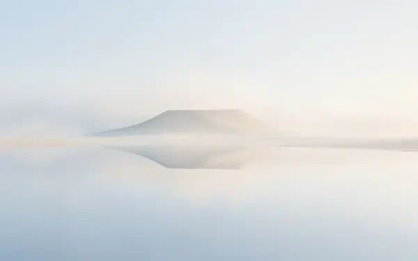 Clean 4K Ultra HD PC desktop wallpaper of a misty mountain reflected in a calm lake, with soft fog and a serene minimalist landscape.