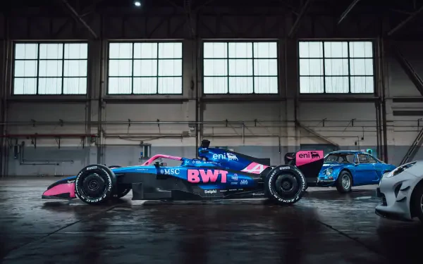 Alpine A526 F1 race car in a dark industrial garage, 8K Ultra HD PC desktop wallpaper and background.