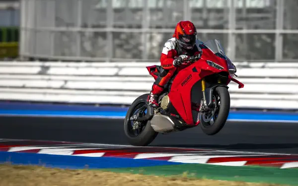 Ducati Panigale V4 and motorcycle racer speeding around a racetrack in 5K Ultra HD desktop wallpaper.
