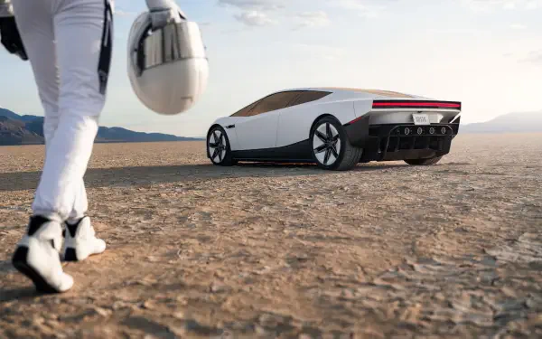 Tesla electric concept car on a desert road with a helmeted figure, featured in a 2K Quad HD PC desktop wallpaper.