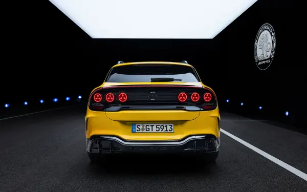 Yellow Mercedes-AMG GT SUV sports car viewed from the rear in a dark tunnel, 2K Quad HD desktop wallpaper and background.