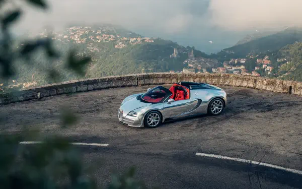 Silver Bugatti Veyron Grand Sport Vitesse convertible at a mountain overlook, featured in a 5K Ultra HD desktop wallpaper.