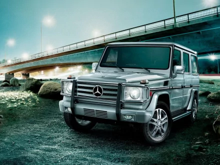 HD PC desktop wallpaper: silver Mercedes G-Class SUV parked by a waterfront beneath a lit highway bridge, moody teal-lit vehicle background.