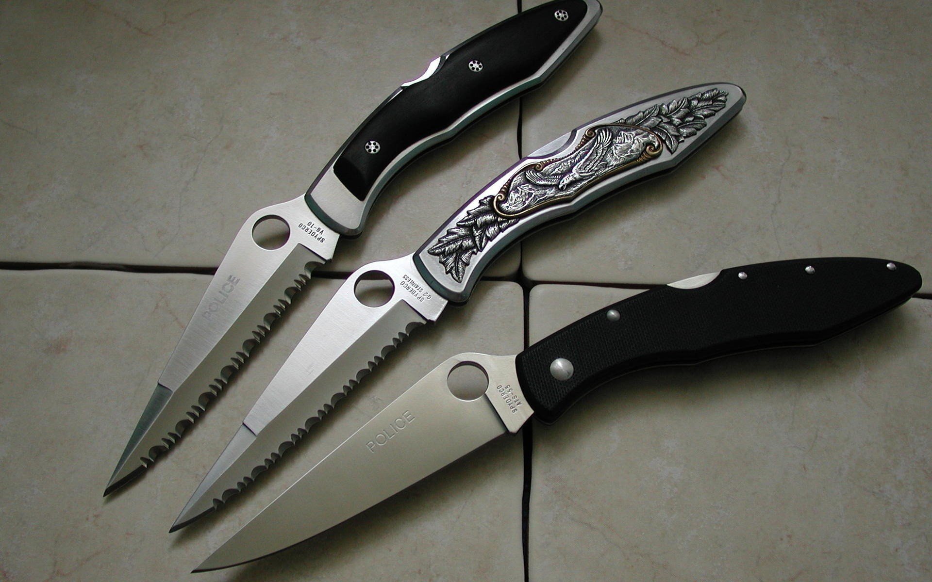 A collection of three man-made knives with various designs and textures displayed on a tiled surface, suitable as an HD PC desktop wallpaper and background.