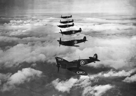 A dramatic HD wallpaper featuring a military aircraft squadron of Supermarine Spitfires in formation soaring above the clouds, showcasing their iconic design and aerial prowess.