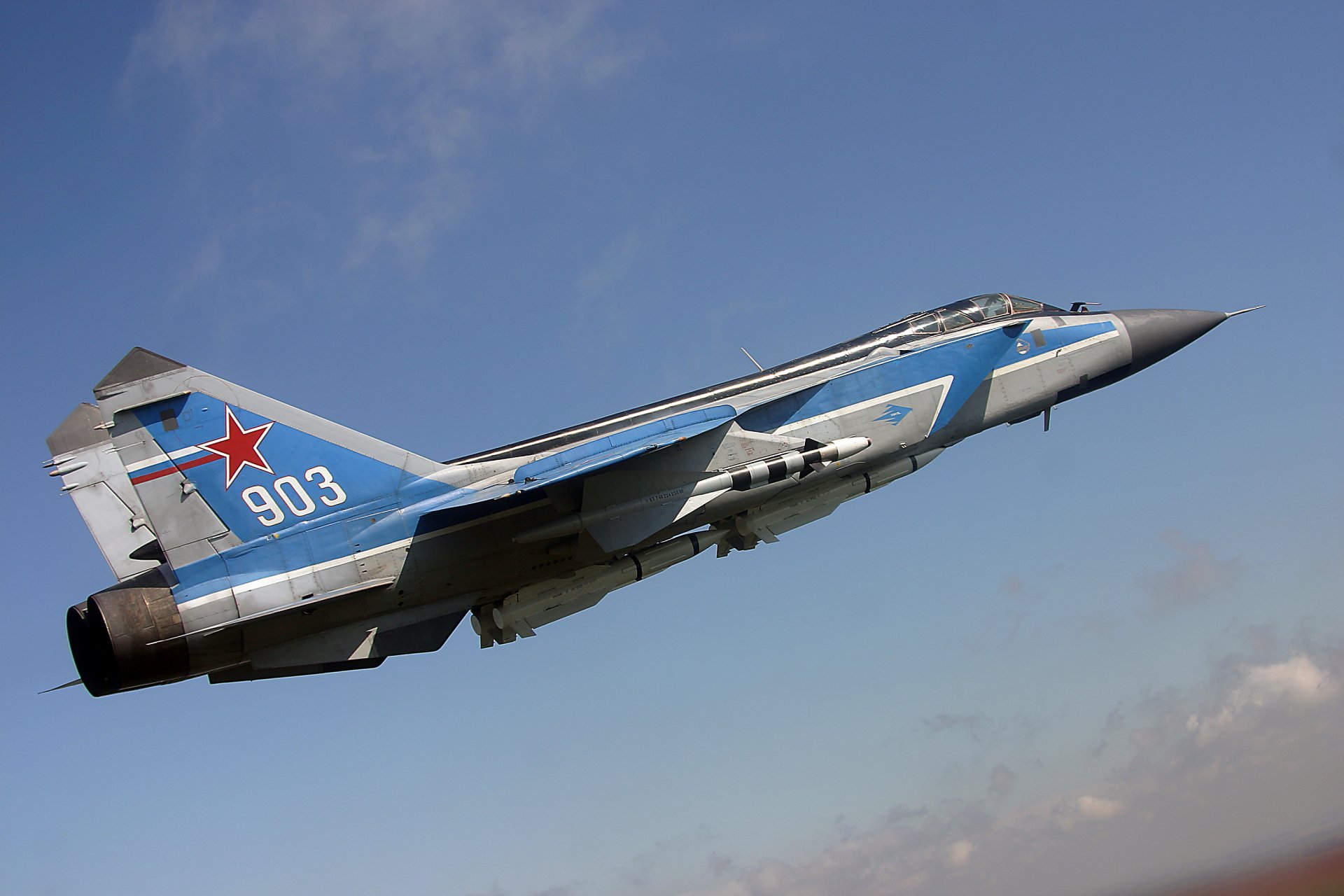 HD desktop wallpaper featuring a Mikoyan MiG-31 military jet fighter warplane soaring against a clear blue sky.
