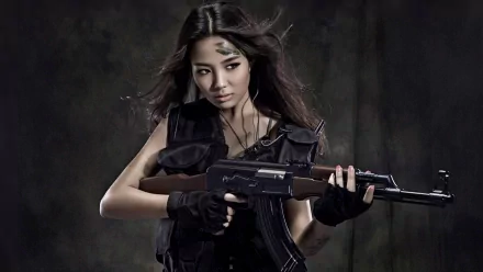 HD wallpaper featuring an Asian woman holding an AK-47 rifle, with a dark background emphasizing the serious and intense atmosphere.