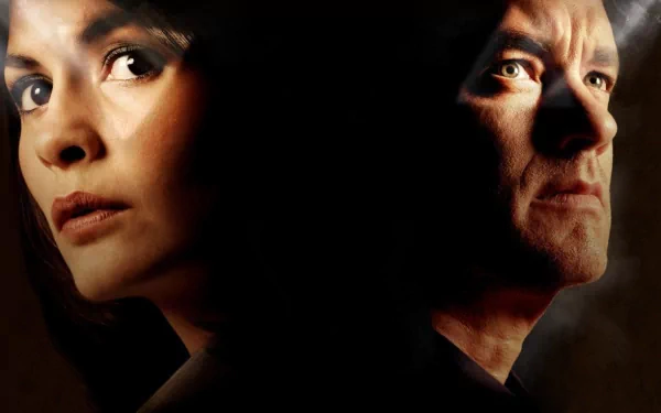 HD wallpaper of Audrey Tautou and Tom Hanks in The Da Vinci Code, featuring intense close-up portraits against a shadowy background.