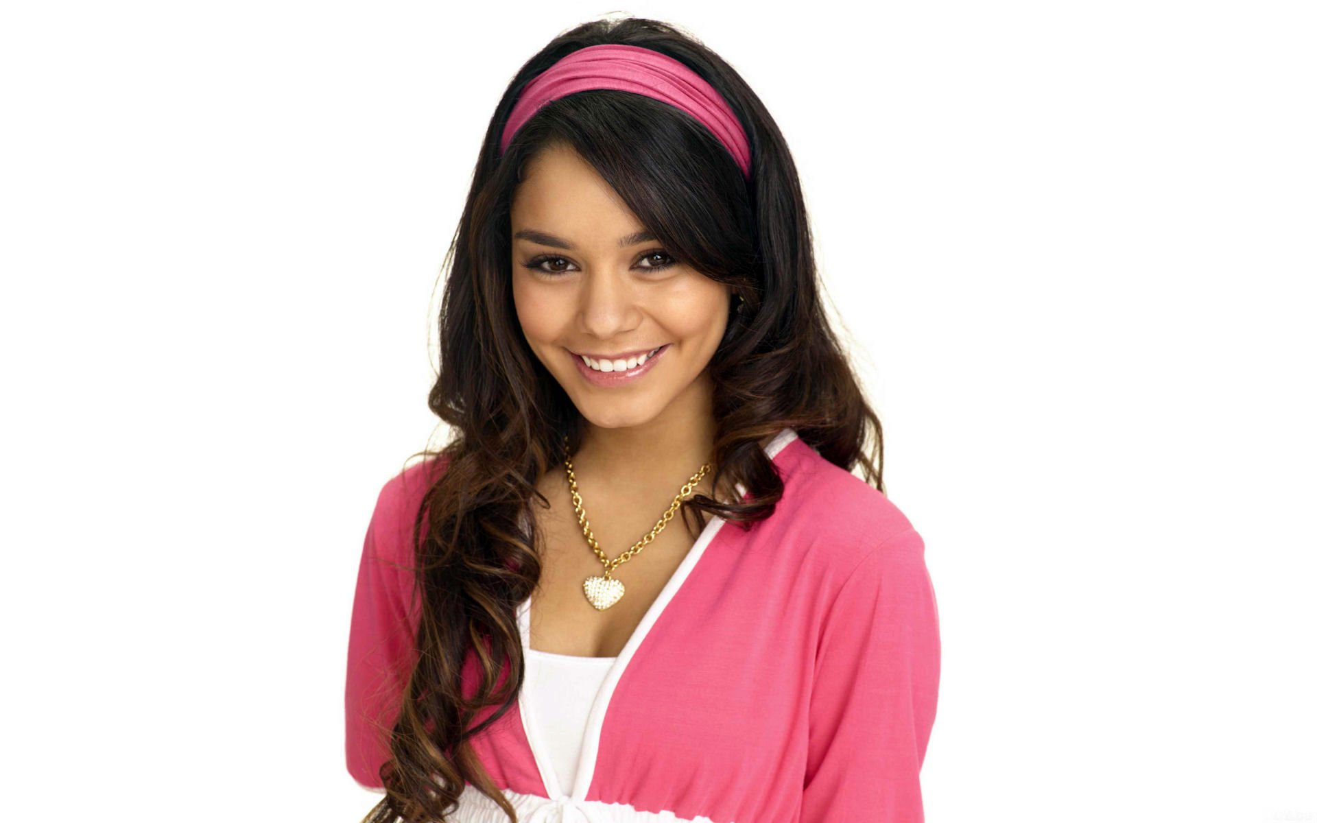 HD PC desktop wallpaper featuring celebrity Vanessa Hudgens smiling, wearing a pink headband and cardigan over a white top against a plain white background.
