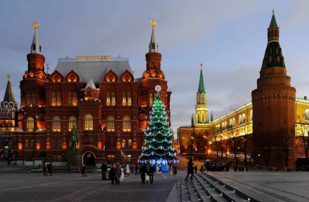 Evening view of Moscow's Red Square with illuminated historic buildings and a decorated Christmas tree, featured as a high-definition desktop wallpaper.