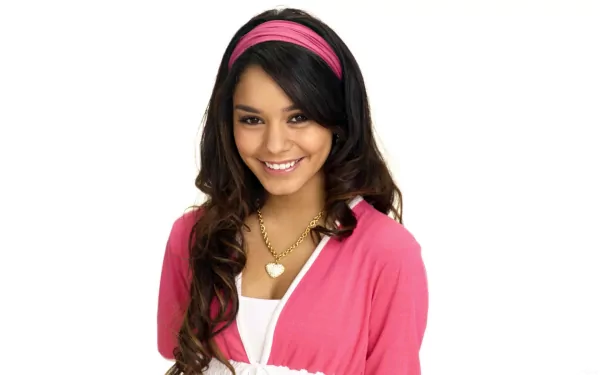 HD PC desktop wallpaper featuring celebrity Vanessa Hudgens smiling, wearing a pink headband and cardigan over a white top against a plain white background.