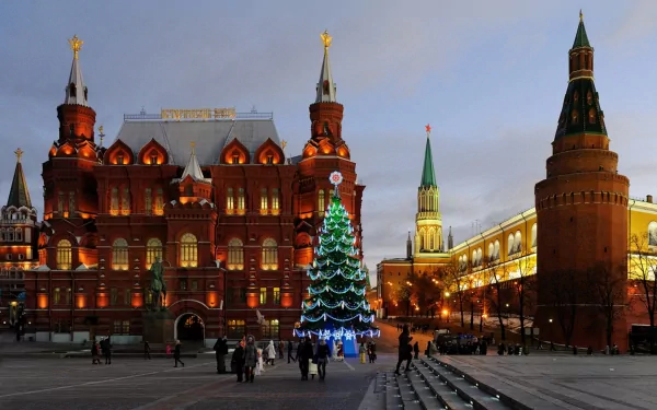 Evening view of Moscow's Red Square with illuminated historic buildings and a decorated Christmas tree, featured as a high-definition desktop wallpaper.
