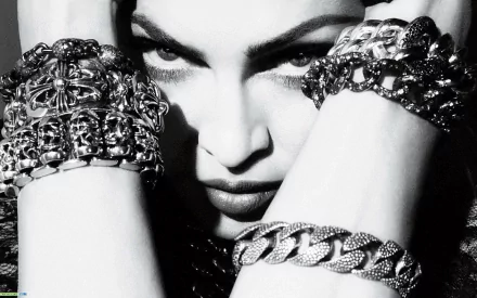 Black-and-white HD PC desktop wallpaper: close-up of a woman with an intense gaze, forearms wearing chunky chain bracelets, music-themed pop aesthetic.