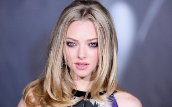 HD wallpaper featuring actress Amanda Seyfried, known for her striking blue eyes and blonde hair, showcasing her captivating presence in a close-up portrait.