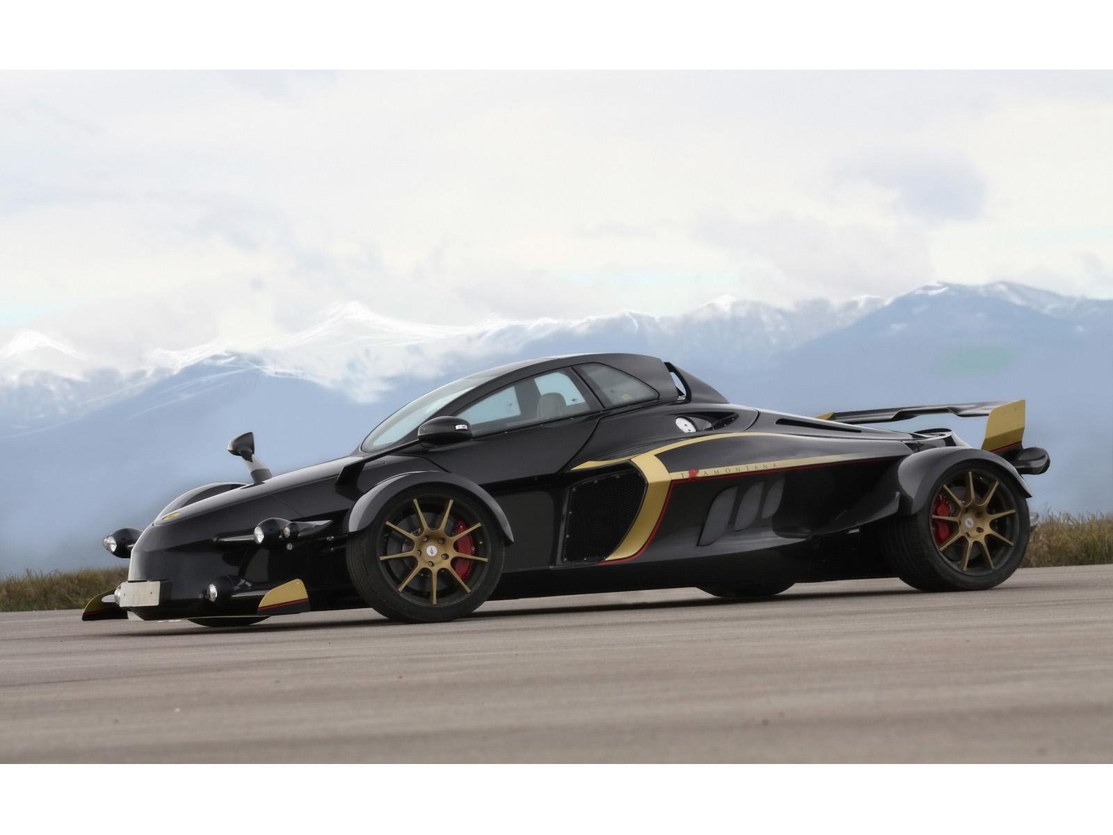 HD desktop wallpaper: black 2009 A.D. Tramontana R race car (Tramontana) on tarmac with mountains in the background.