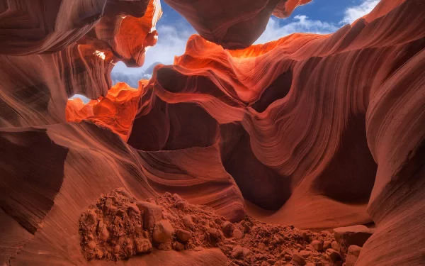 HD desktop wallpaper showcasing the stunning natural rock formations and vibrant colors of Antelope Canyon under a bright blue sky.