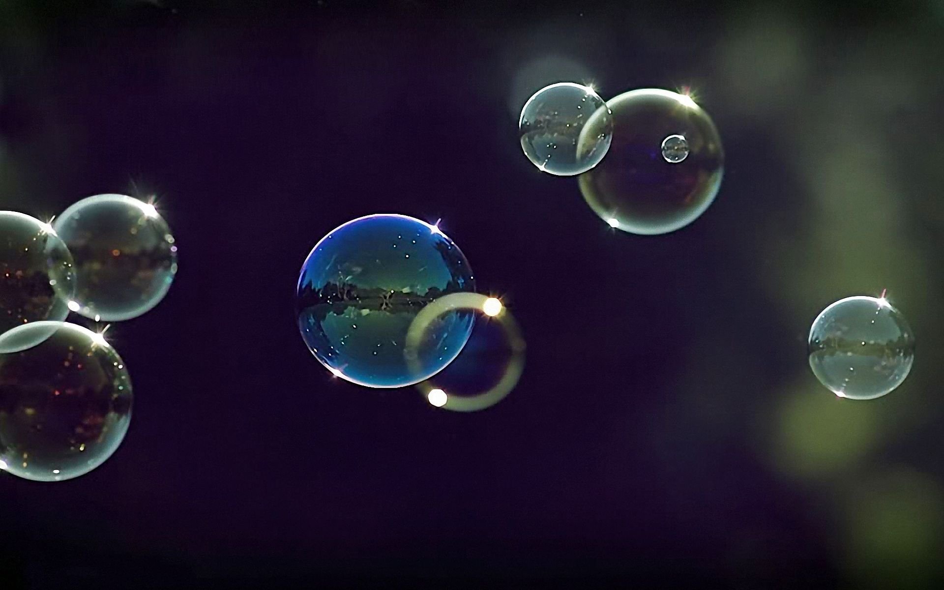 HD PC desktop wallpaper featuring a close-up of delicate, reflective bubbles floating against a dark, blurred background in a detailed photography shot.