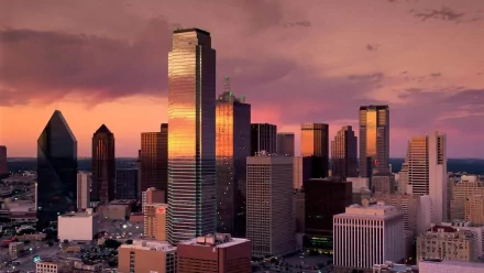 HD desktop wallpaper of Dallas, Texas featuring a stunning cityscape with prominent skyscrapers under a vibrant sunset sky.