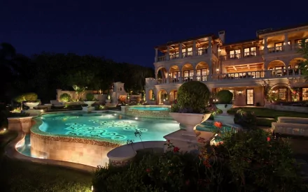 A stunning HD wallpaper featuring a luxurious mansion at night, complete with a glimmering pool and beautifully landscaped gardens, creating an elegant and serene atmosphere.
