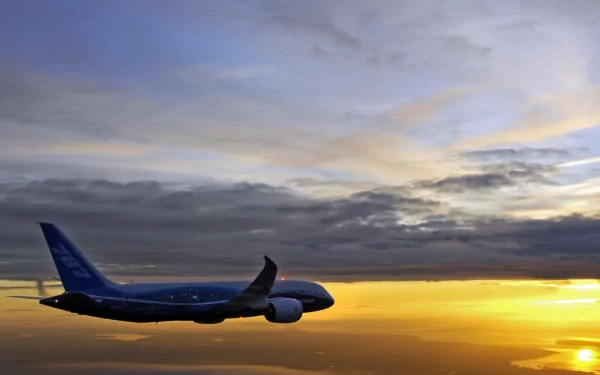 HD desktop wallpaper of a Boeing 787 Dreamliner aircraft flying against a sunset sky, showcasing the sleek design of this advanced vehicle.