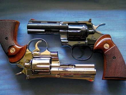HD desktop wallpaper featuring a close-up of two man-made Colt Python revolvers with detailed wooden grips and metallic finishes.