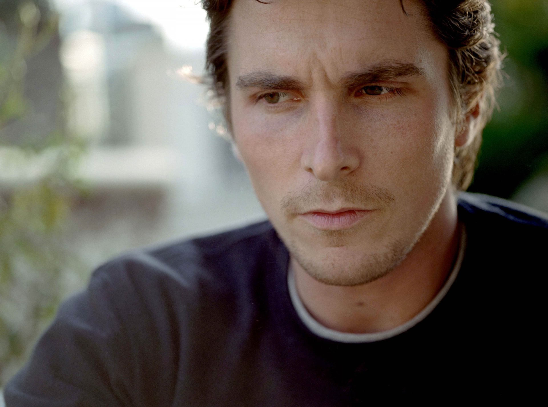 HD PC desktop wallpaper featuring a close-up of celebrity Christian Bale with a contemplative expression against a softly blurred background.