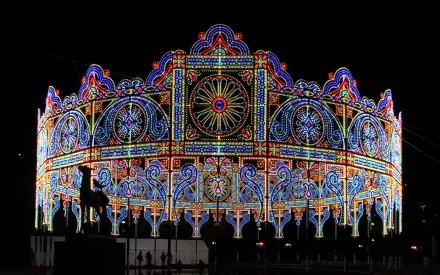 HD PC desktop wallpaper featuring a vibrant, circular light installation with intricate, colorful patterns illuminated against a dark night sky in a photography-focused composition.