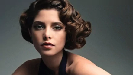 A striking HD wallpaper featuring celebrity Ashley Greene, showcasing her elegant look with vintage-inspired curls and a sophisticated expression against a soft background.