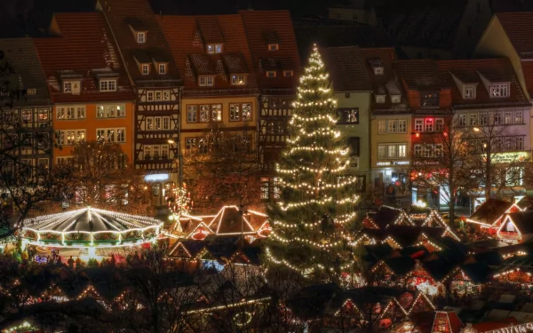 HD PC desktop wallpaper and background: man-made Christmas market at night with a tall lit tree, rows of illuminated stalls, a carousel and glowing historic buildings.