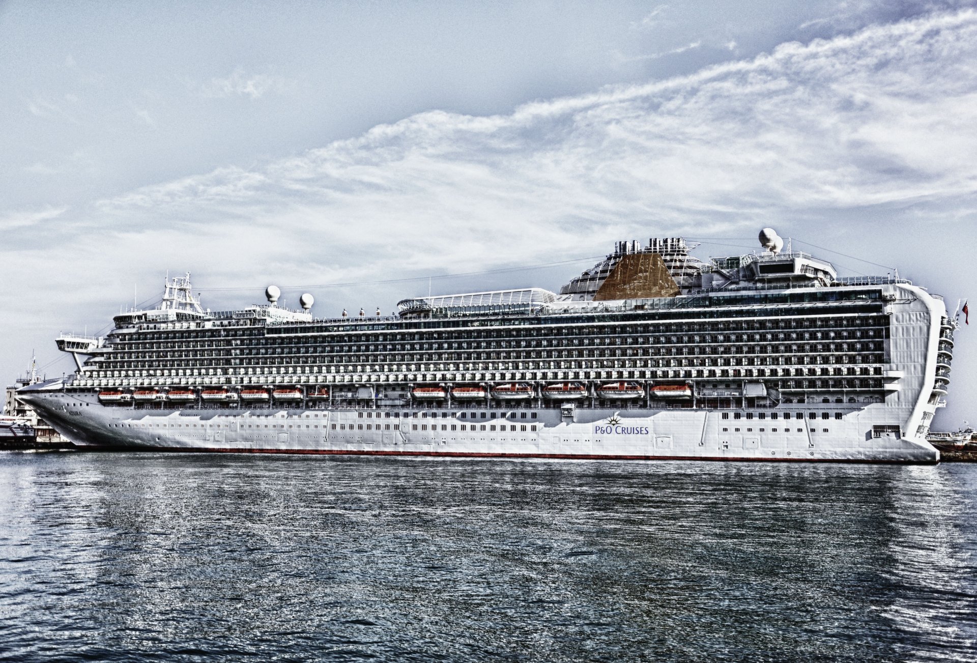 A high-resolution 4K Ultra HD image of a large cruise ship docked at a harbor, featuring detailed exterior views and calm water reflections.
