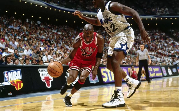 Michael Jordan of the Chicago Bulls dribbles past Shaquille O'Neal during a lively basketball matchup, capturing the intensity and skill of the sport in this HD wallpaper.