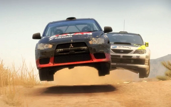 HD PC desktop wallpaper/background of two rallye vehicles airborne over a dusty dirt track, the front car mid-jump with a second car close behind.