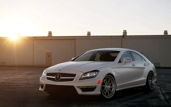 A sleek white Mercedes coupe is parked on a sunset-lit pavement, showcasing its stylish design. This HD wallpaper captures the essence of luxury and performance.