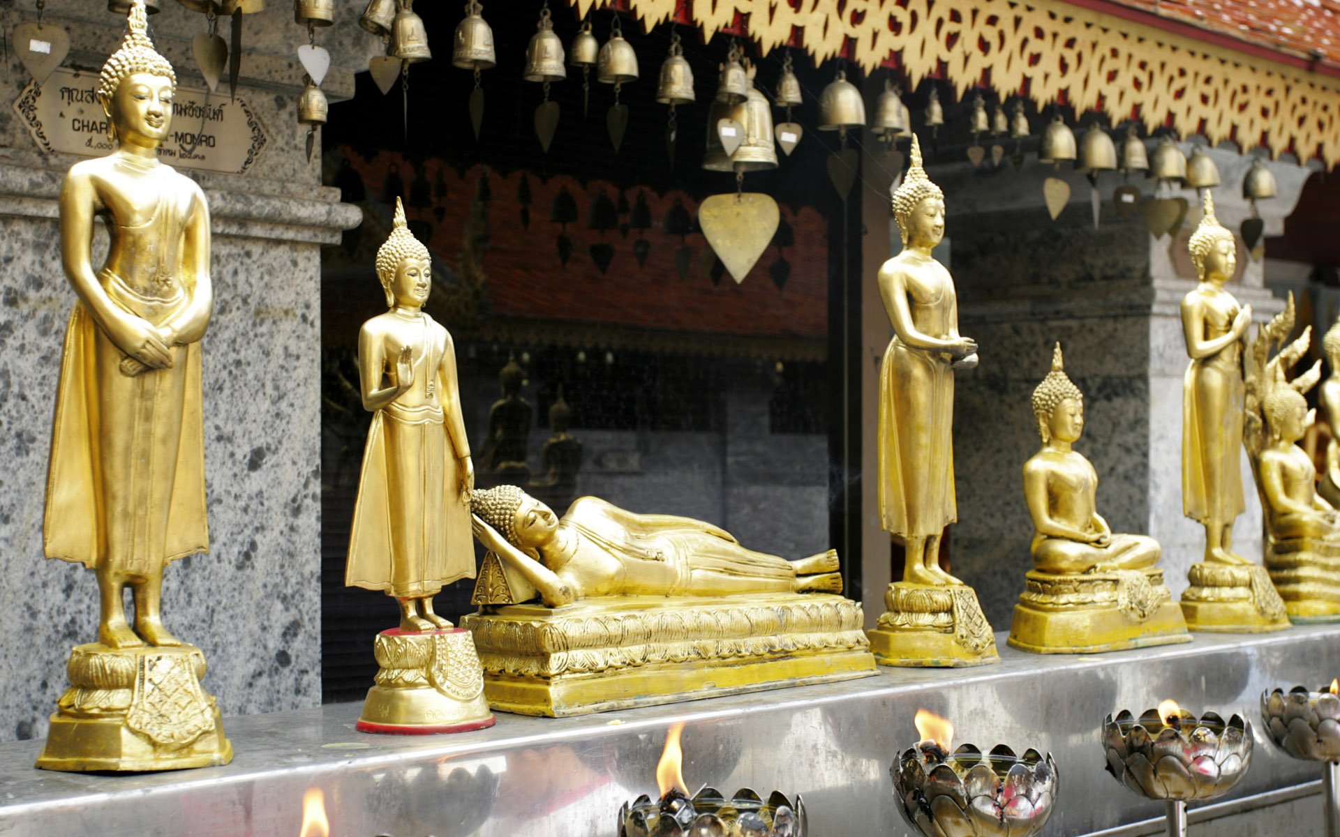 HD desktop wallpaper featuring golden Buddhist statues in various postures, set against an ornate temple backdrop, reflecting religious and spiritual themes.