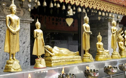 HD desktop wallpaper featuring golden Buddhist statues in various postures, set against an ornate temple backdrop, reflecting religious and spiritual themes.