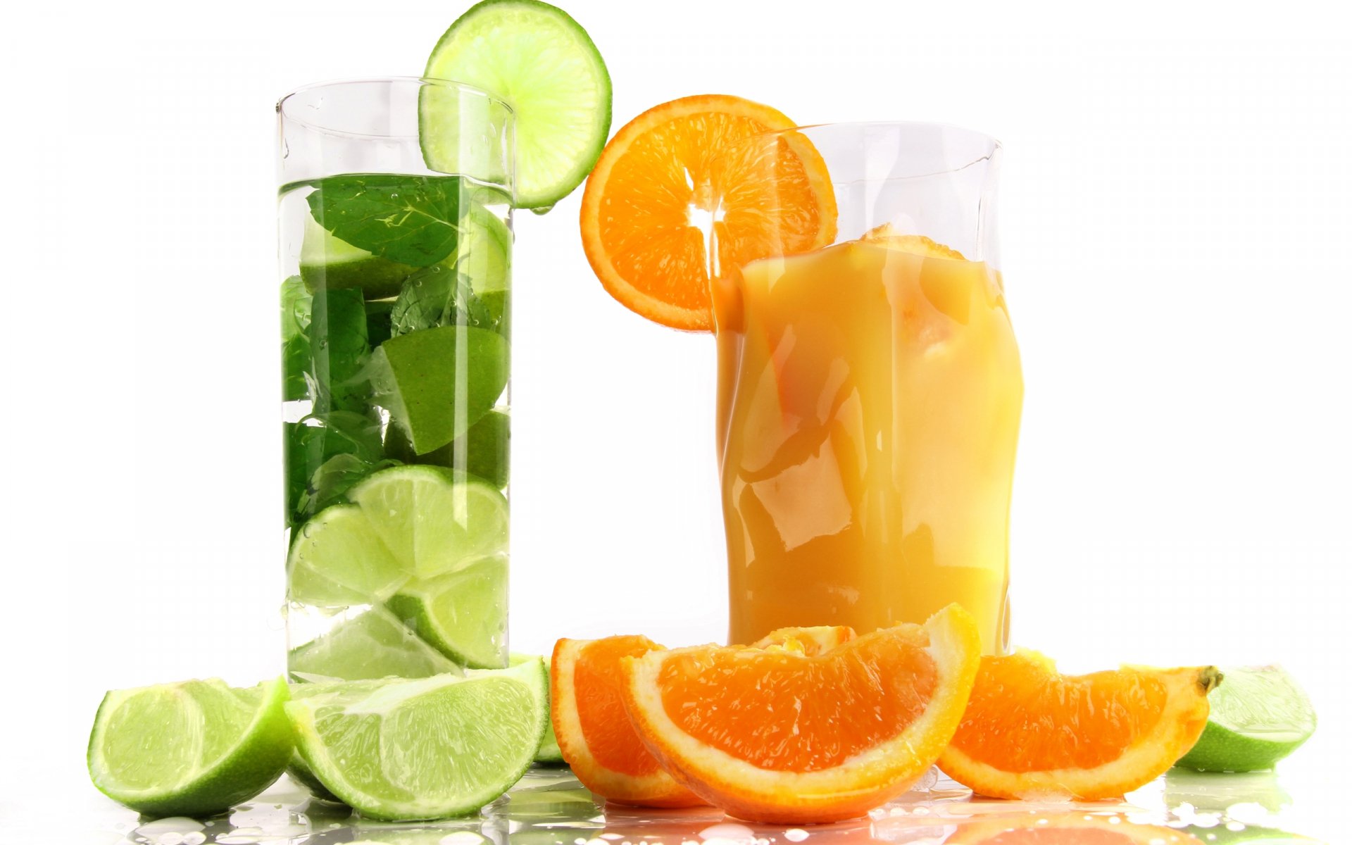 HD PC desktop wallpaper featuring refreshing citrus drinks, including a green lime cocktail and an orange juice glass, with fresh lime and orange slices.