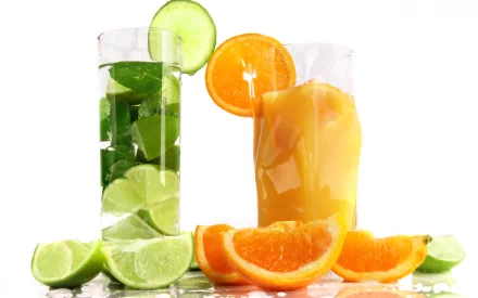 HD PC desktop wallpaper featuring refreshing citrus drinks, including a green lime cocktail and an orange juice glass, with fresh lime and orange slices.