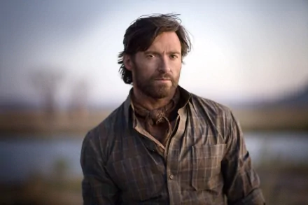 HD desktop wallpaper featuring Hugh Jackman as a drover in the movie Australia, set against a soft, natural Australian landscape background.