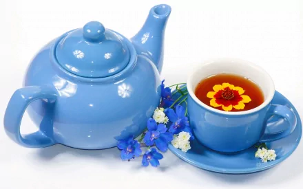 HD PC desktop wallpaper featuring a blue teapot and matching cup of tea with a floating flower, accompanied by small blue and white blossoms.