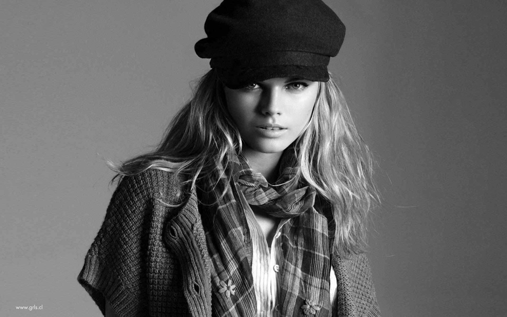 Black and white portrait of celebrity Karlie Kloss, featuring her in a stylish hat and scarf, serving as an HD desktop wallpaper and background.