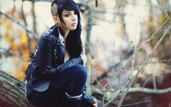A woman with an emo style sits on a tree branch, surrounded by soft autumn colors, creating a striking and atmospheric HD PC desktop wallpaper.