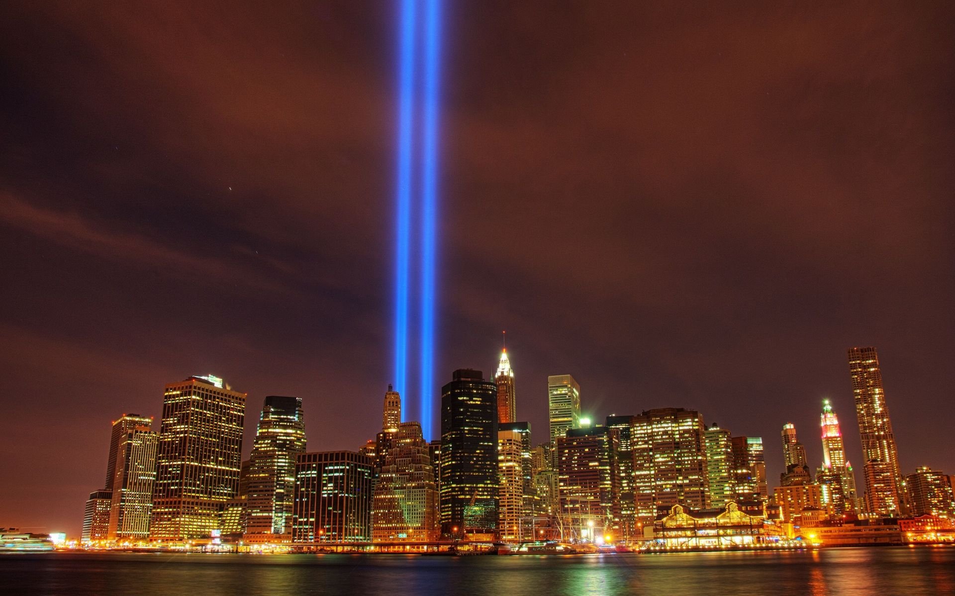 Nighttime view of Manhattan's skyline in New York with the World Trade Center Tribute in Light beams shining into the sky, captured as an HD desktop wallpaper.