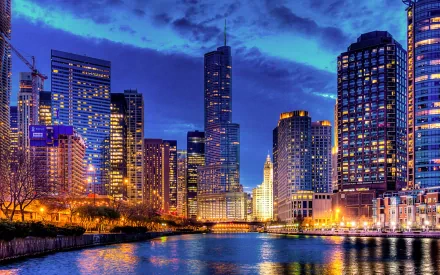 HD desktop wallpaper showcasing the illuminated Chicago skyline at dusk, featuring man-made skyscrapers reflecting on the river.
