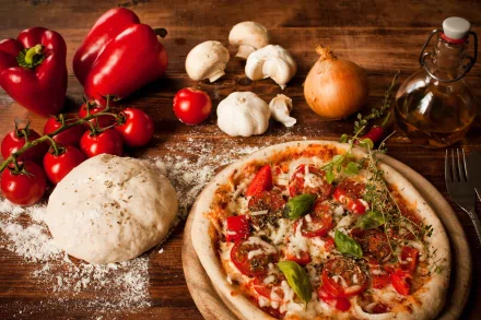 A freshly baked pizza topped with tomatoes, peppers, and herbs sits on a wooden table, surrounded by ingredients like mushrooms, garlic, and dough, creating a vibrant food scene.