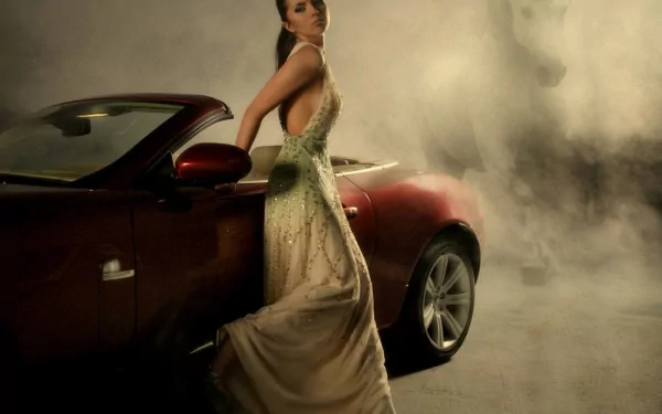 HD desktop wallpaper featuring a fashionable woman in an elegant gown leaning against a sleek red convertible, set against a smoky, atmospheric background.