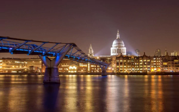 London night view of the Millennium Bridge and illuminated St Paul's across the Thames, man-made structures reflecting on the water. 2K Quad HD PC desktop wallpaper/background.