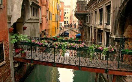 A vibrant scene in Venice featuring colorful buildings, a flower-adorned bridge, and a serene canal, captured in HD for a stunning desktop wallpaper.