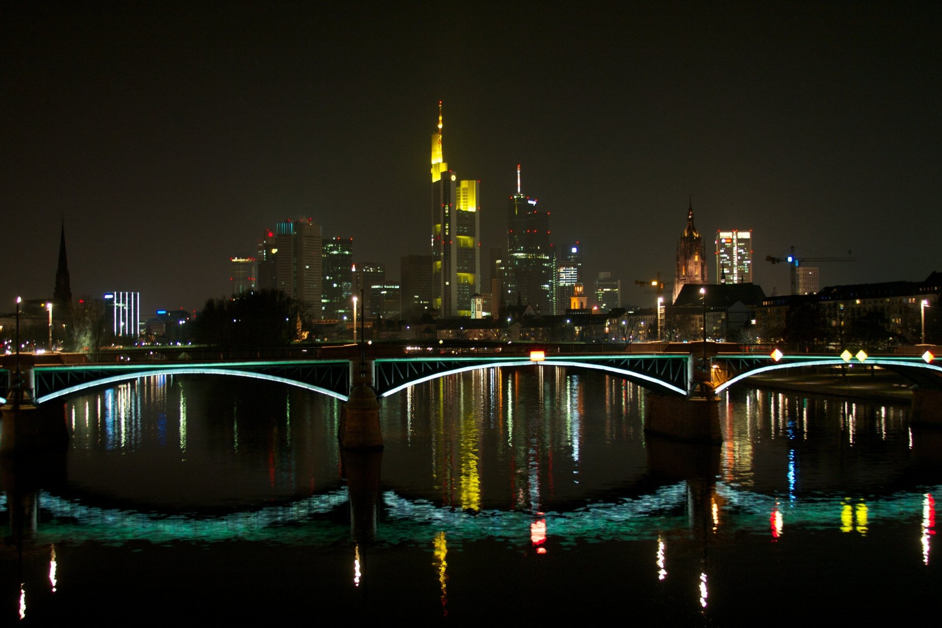 Frankfurt night skyline with illuminated skyscrapers and an arched bridge reflecting on the river — man-made 2K Quad HD PC desktop wallpaper/background.