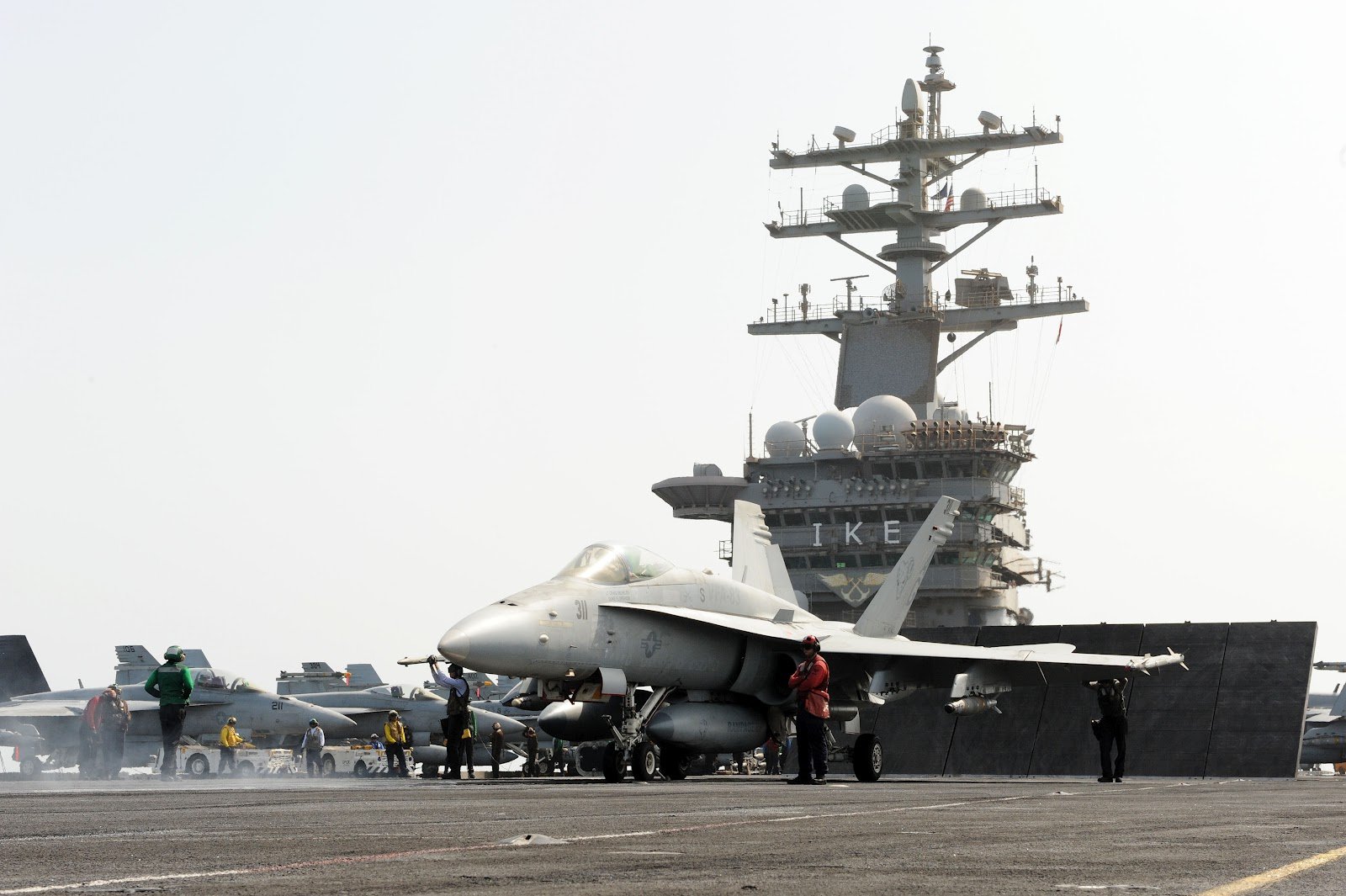 HD desktop wallpaper featuring a military McDonnell Douglas F/A-18 Hornet jet on the deck of an aircraft carrier.